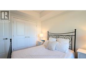 A bedroom with a bed, nightstand, and lamp.