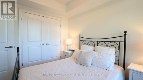 A bedroom with a bed, nightstand, and lamp.