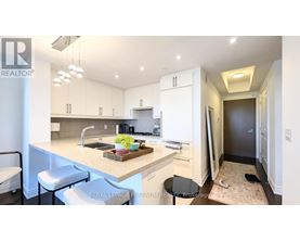 A kitchen with white cabinets and a marble countertop.