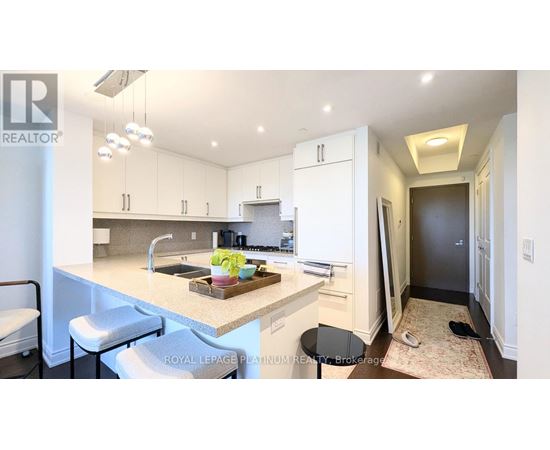 A kitchen with white cabinets and a marble countertop.