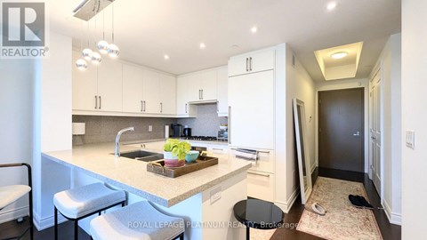 A kitchen with white cabinets and a marble countertop.