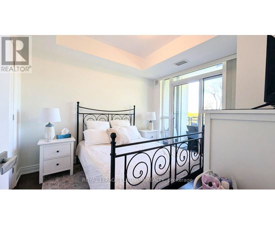 A bedroom with a black metal bed frame and white bedding.