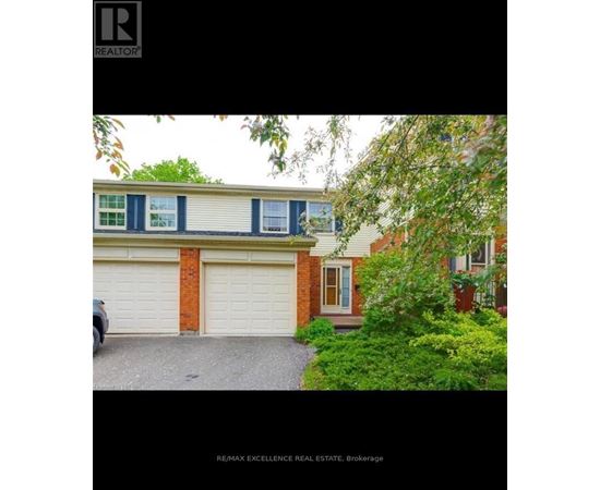 A house with a garage and a tree in front.