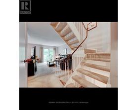 A staircase with a beige carpeted runner and white risers leads up to a balcony.
