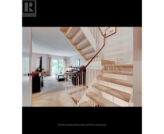 A staircase with a beige carpeted runner and white risers leads up to a balcony.
