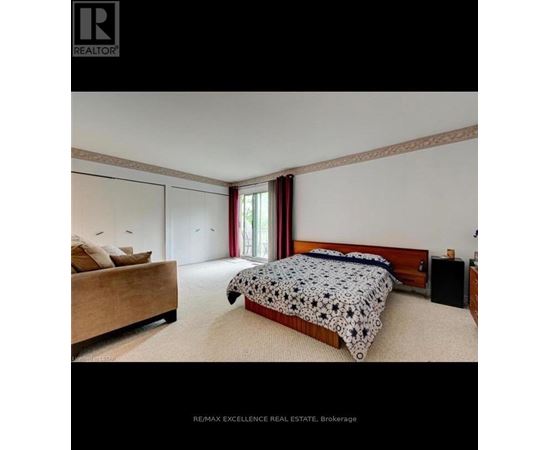 A bedroom with a bed, nightstand, and window.