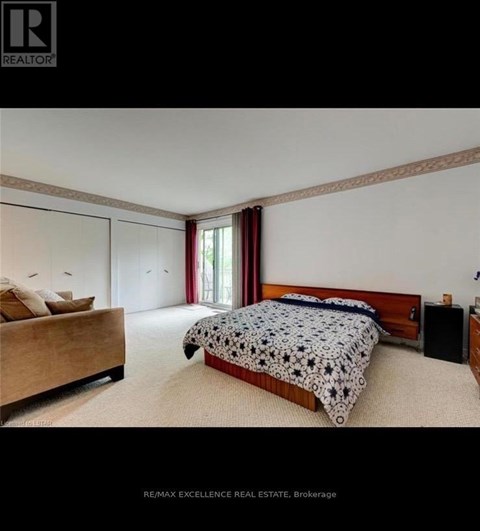 A bedroom with a bed, nightstand, and window.