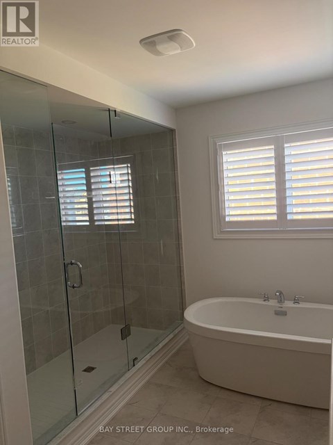 A bathroom with a glass shower stall and a white bathtub.