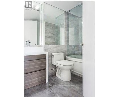 A white toilet in a bathroom with a glass shower door.