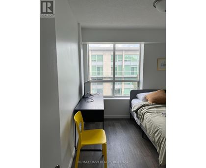 A bedroom with a bed, desk, and chair.