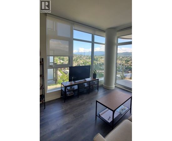 A living room with a television and a view of the city.