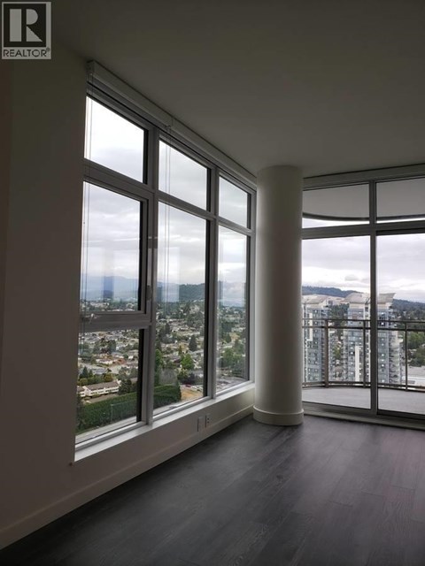 A room with a large window overlooking a cityscape.