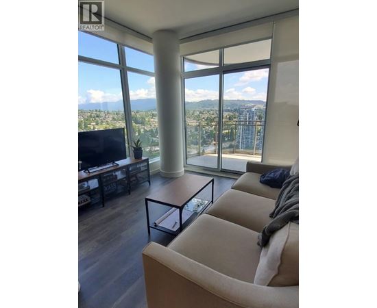 A living room with a large window overlooking a cityscape.