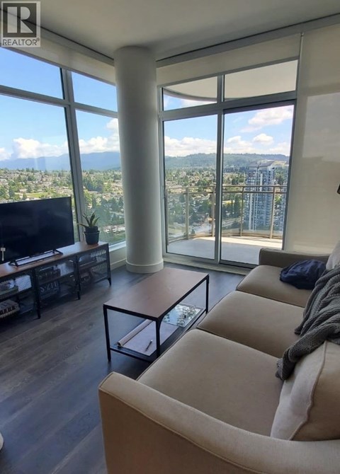 A living room with a large window overlooking a cityscape.