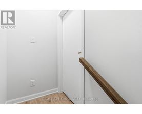 A white wall with a wooden staircase.
