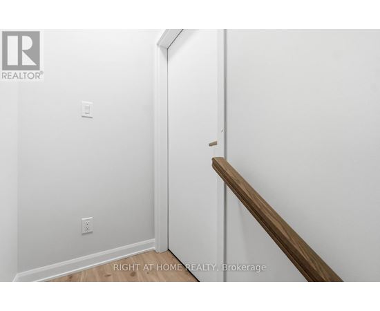 A white wall with a wooden staircase.