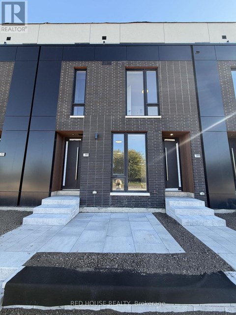 A modern house with a black and white front yard.