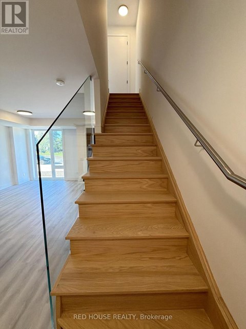 A long flight of wooden stairs with a metal handrail.