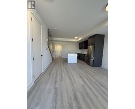 A spacious kitchen with white appliances and dark wood cabinets.