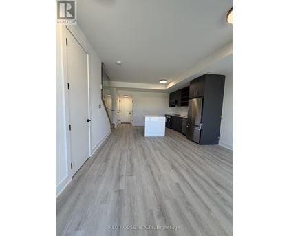 A spacious kitchen with white appliances and dark wood cabinets.