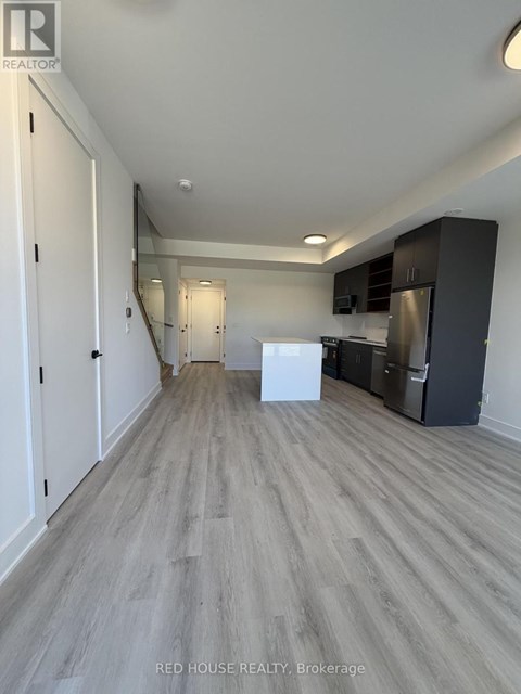 A spacious kitchen with white appliances and dark wood cabinets.