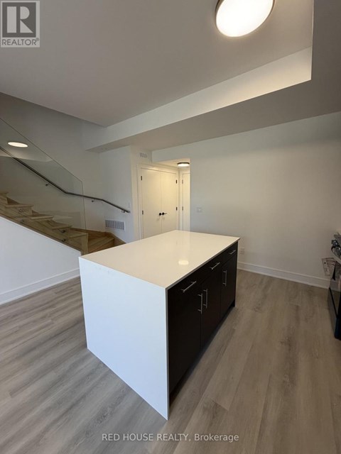 A white kitchen island with black cabinets in a modern room.