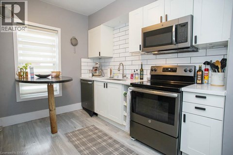 A kitchen with a black oven and white cabinets.