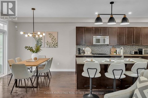 A well-lit kitchen with a dining table and chairs.
