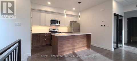 A modern kitchen with a wooden island and stainless steel appliances.