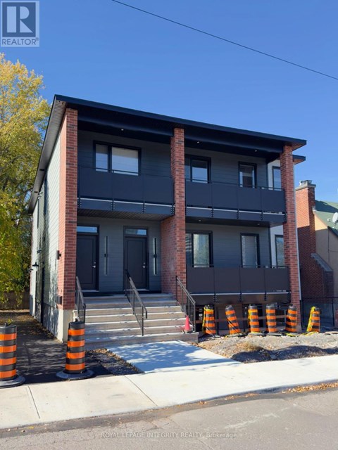 A two-story building with a balcony and a black awning.