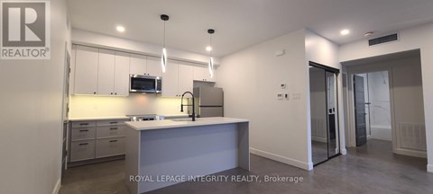 A kitchen with a sink and a microwave.