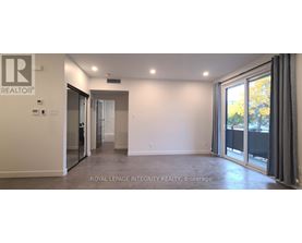 A spacious room with a sliding glass door leading to a balcony.