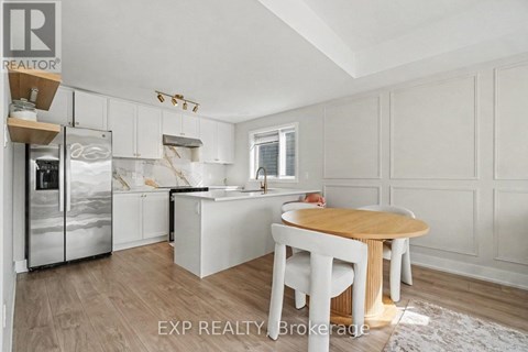 A kitchen with white cabinets and a wooden table.