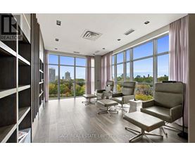 A spacious room with a view of the city skyline through large windows.