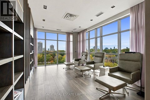 A spacious room with a view of the city skyline through large windows.