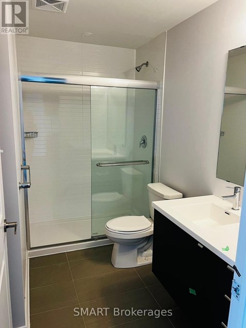 A bathroom with a toilet, sink, and shower.