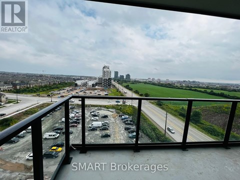 A view from a balcony overlooking a busy highway and a city skyline.