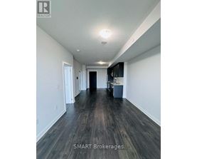 A long hallway with wood floors and white walls.