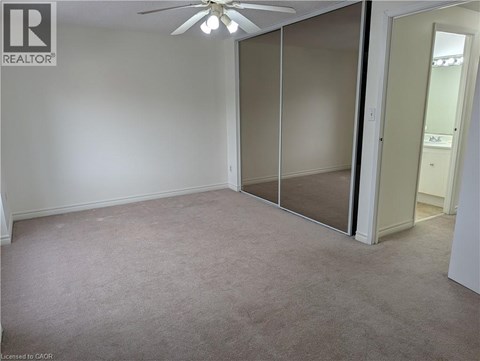 A room with a ceiling fan and sliding glass doors.