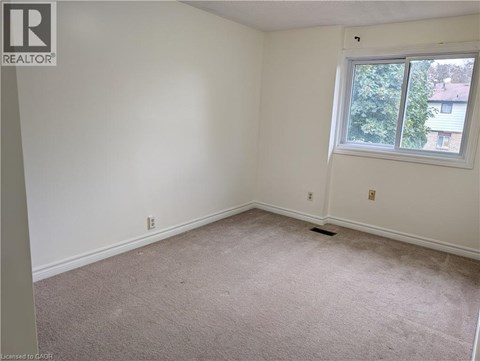 A room with a carpeted floor and a window.
