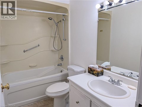 A white bathroom with a toilet, sink, and bathtub.