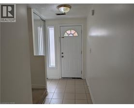 A hallway with a white door and a window.