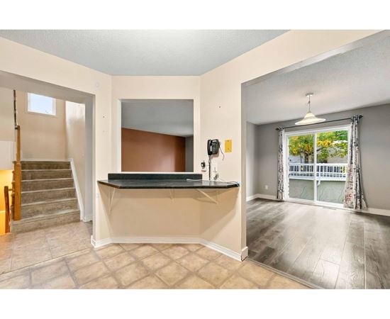 A room with a bar counter and a staircase.