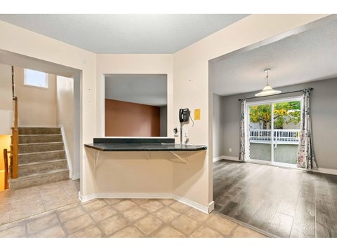 A room with a bar counter and a staircase.