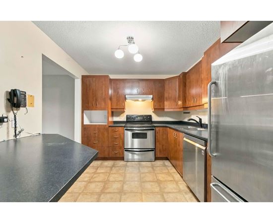 A kitchen with wooden cabinets and stainless steel appliances.