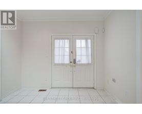 A white door with a glass window is in the middle of a white room.