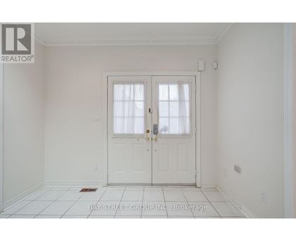 A white door with a glass window is in the middle of a white room.