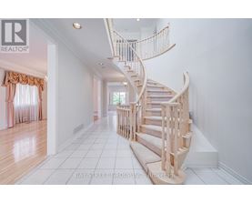 A white hallway with a spiral staircase and a window with curtains.