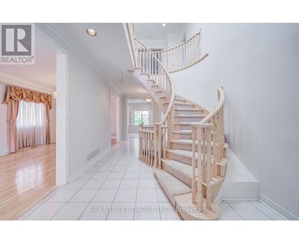 A white hallway with a spiral staircase and a window with curtains.