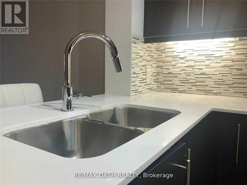 A modern kitchen with a stainless steel sink and a chrome faucet.